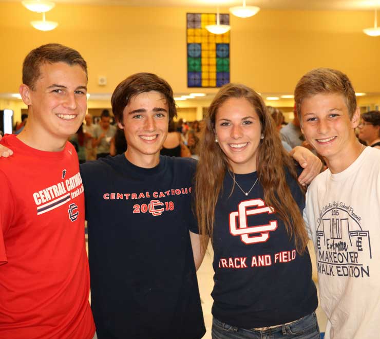 Four smiling students in the Baroni Dining Hall.